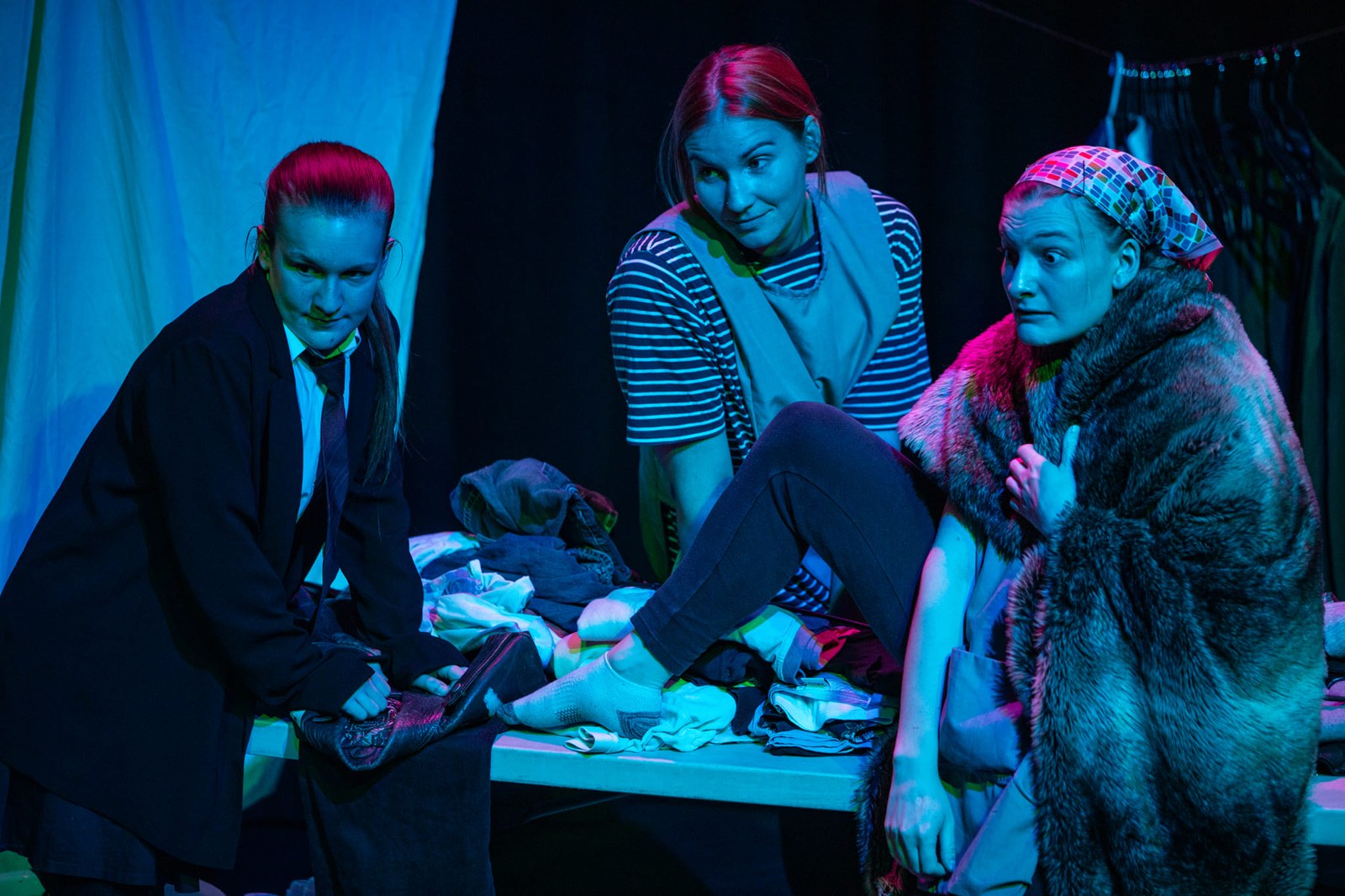 Three performers in Dirty under blue and magenta lighting