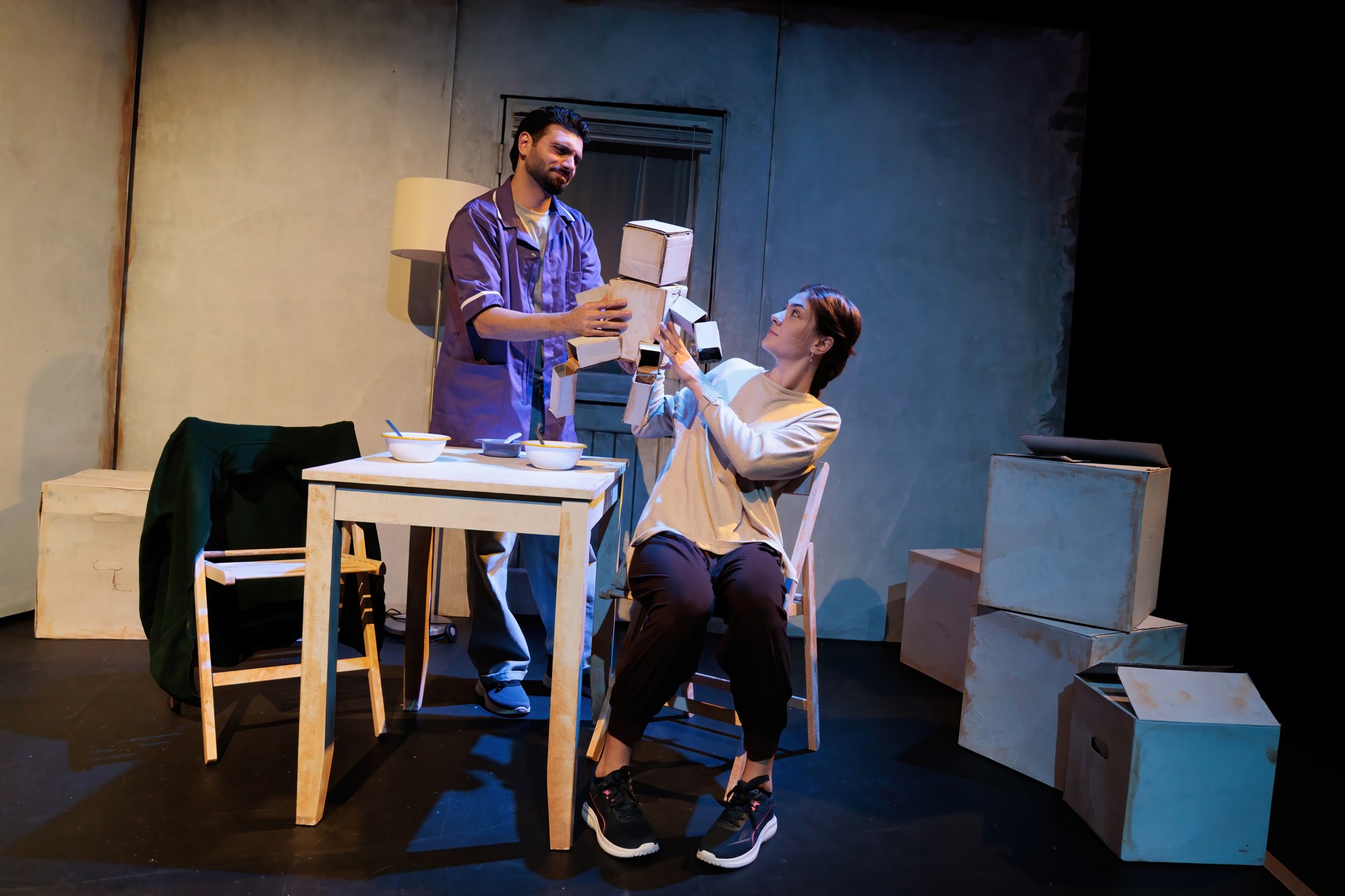 Two performers holding the cardboard doll representing their toddler son in Lightstreams